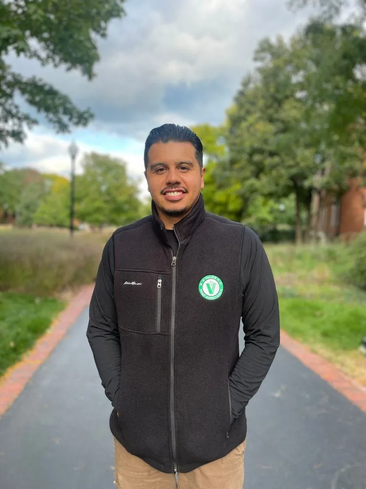 Valor Property Inspections team member in a black fleece jacket with company logo, standing on a path