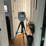 Breeze ET device on a tripod in a home hallway, used for air quality assessment
