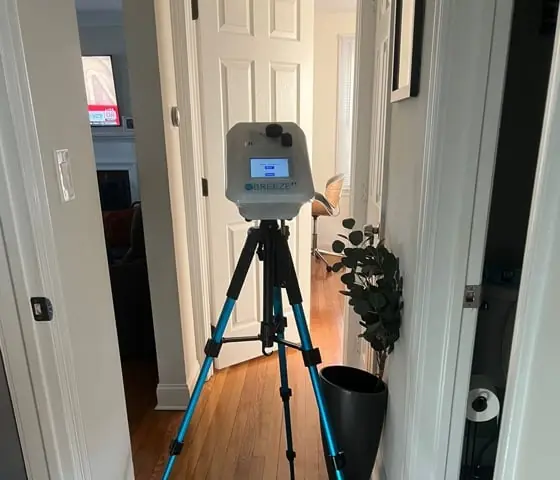 Breeze ET device on a tripod in a home hallway, used for air quality assessment