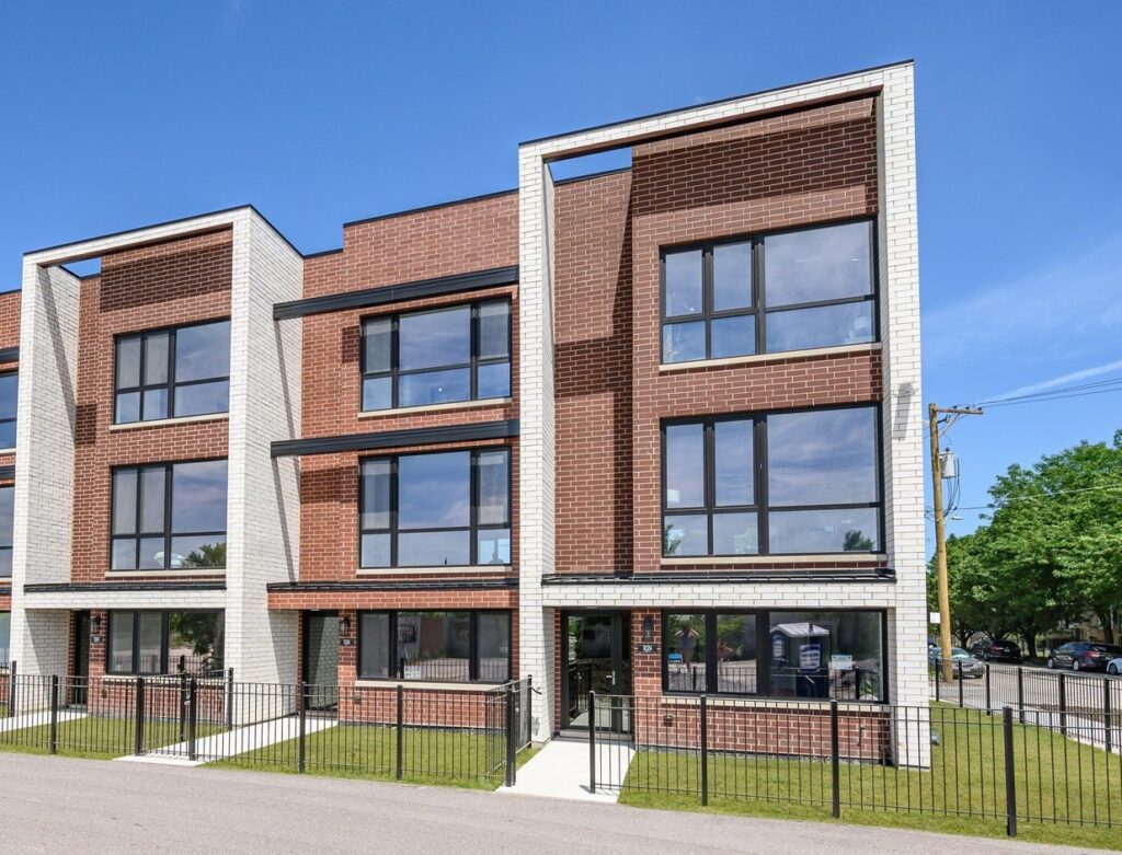 Condo Inspection — Modern brick and white townhomes with large windows under a clear blue sky