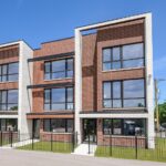 Condo Inspection — Modern brick and white townhomes with large windows under a clear blue sky